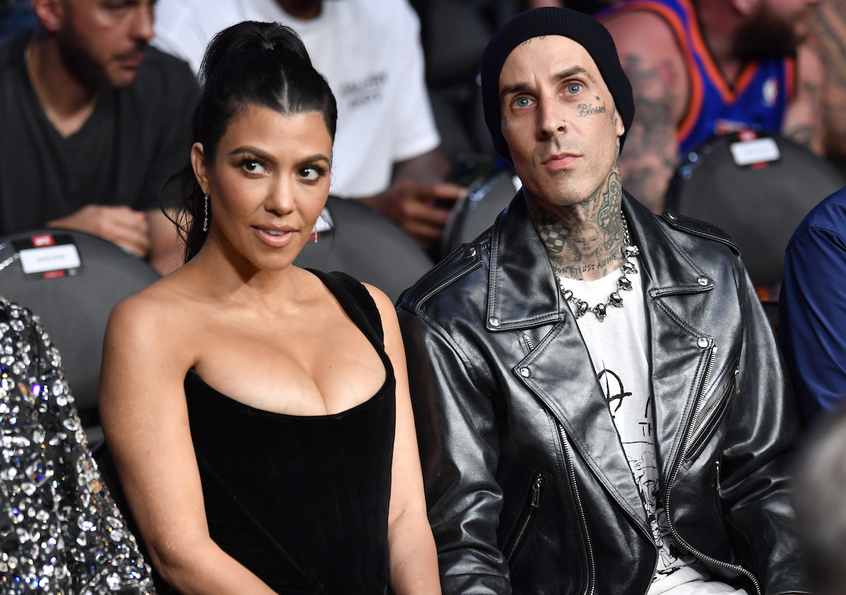 Kourtney Kardashian and Travis Barker sit together at an event.