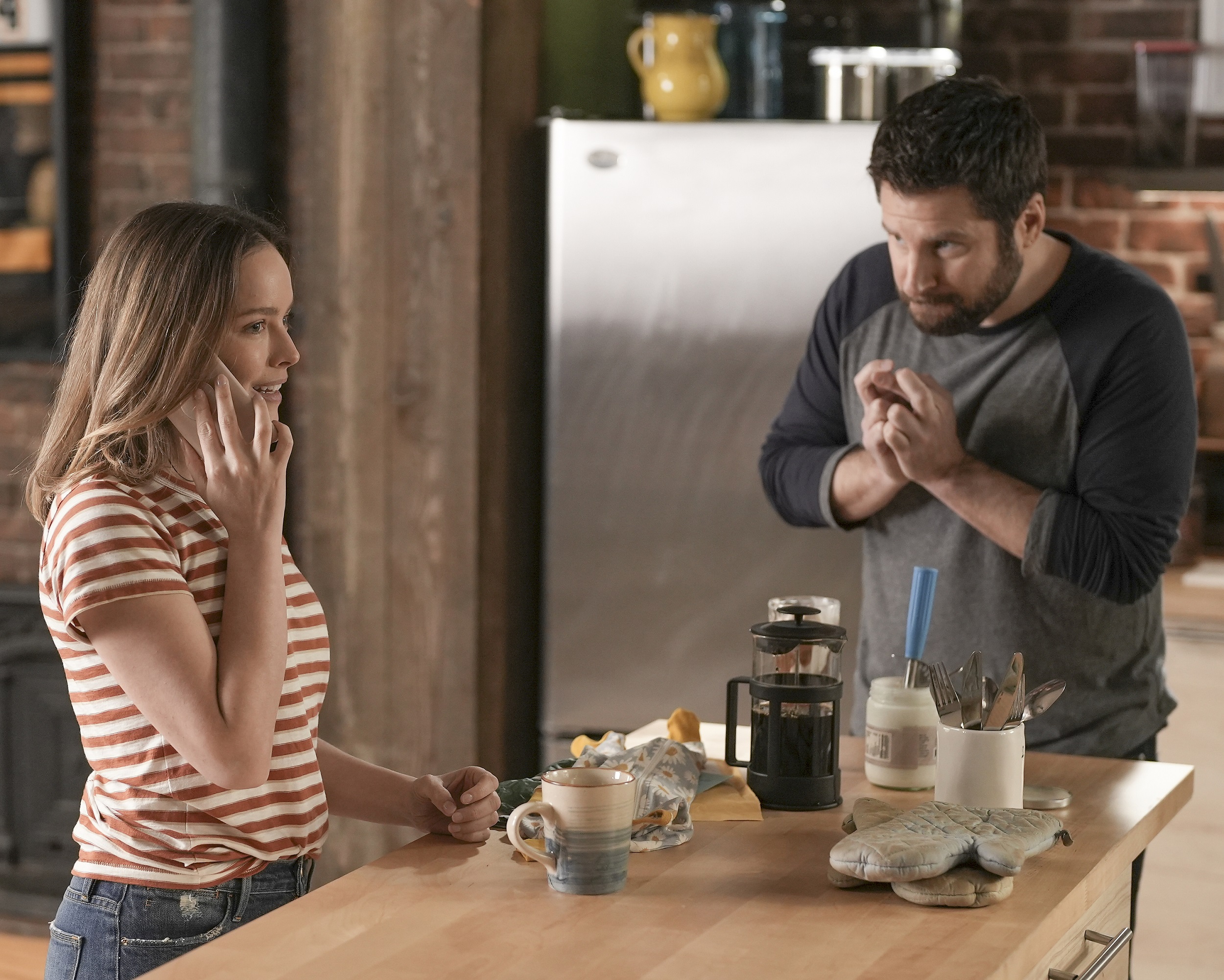 'A Million Little Things' Season 4 Allison Miller as Maggie Bloom on the phone and James Roday Rodriguez as Gary Mendez crossing his fingers