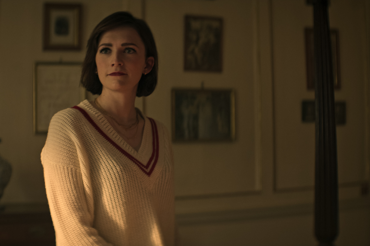 In You Season 4, Kate wears a cream-colored sweater with a red stripe.