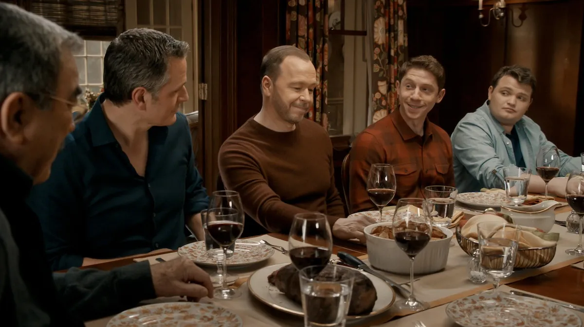 Donnie Wahlberg sitting at the Reagan family dinner table in a scene from 'Blue Bloods'