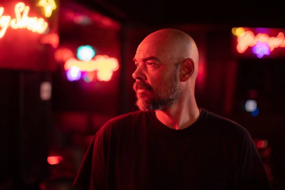 Aaron Goodwin of 'Ghost Adventurse' in profile and lit by reddish light