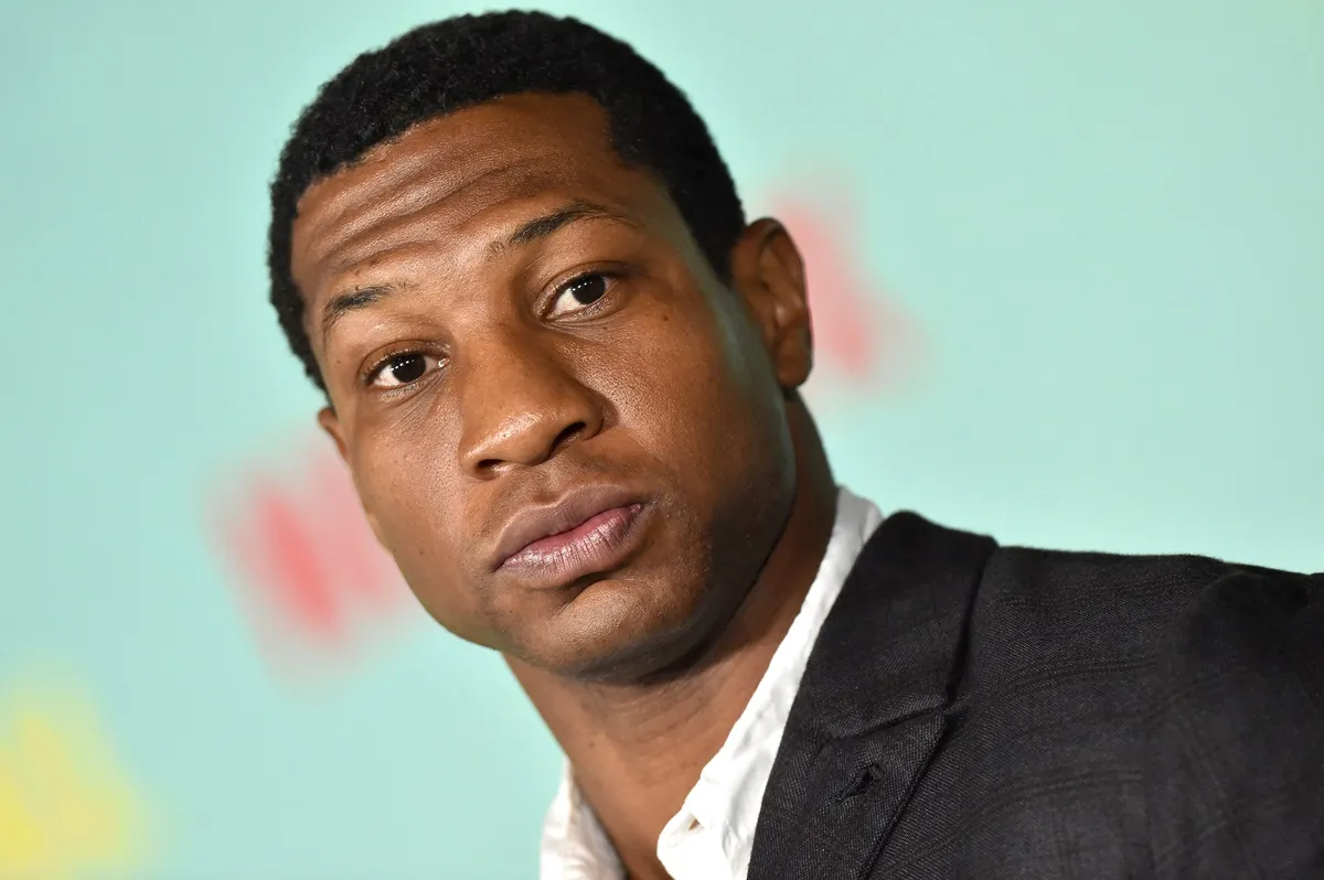 Jonathan Majors posing in a suit at "The Harder They Fall".