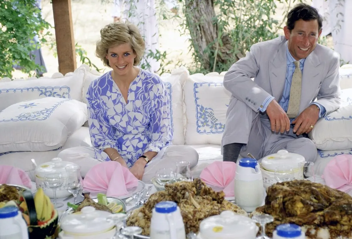Princess Diana and then-Prince Charles laughing together during a desert picnic in Adu Dhabi