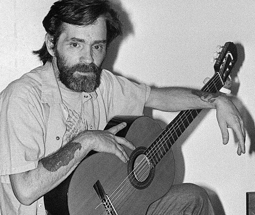 Charles Manson with a guitar