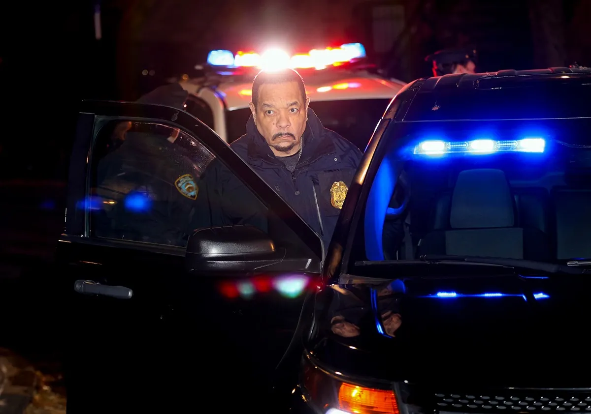 Ice-T posing beside a black car on the set of 'Law & Order SVU'.